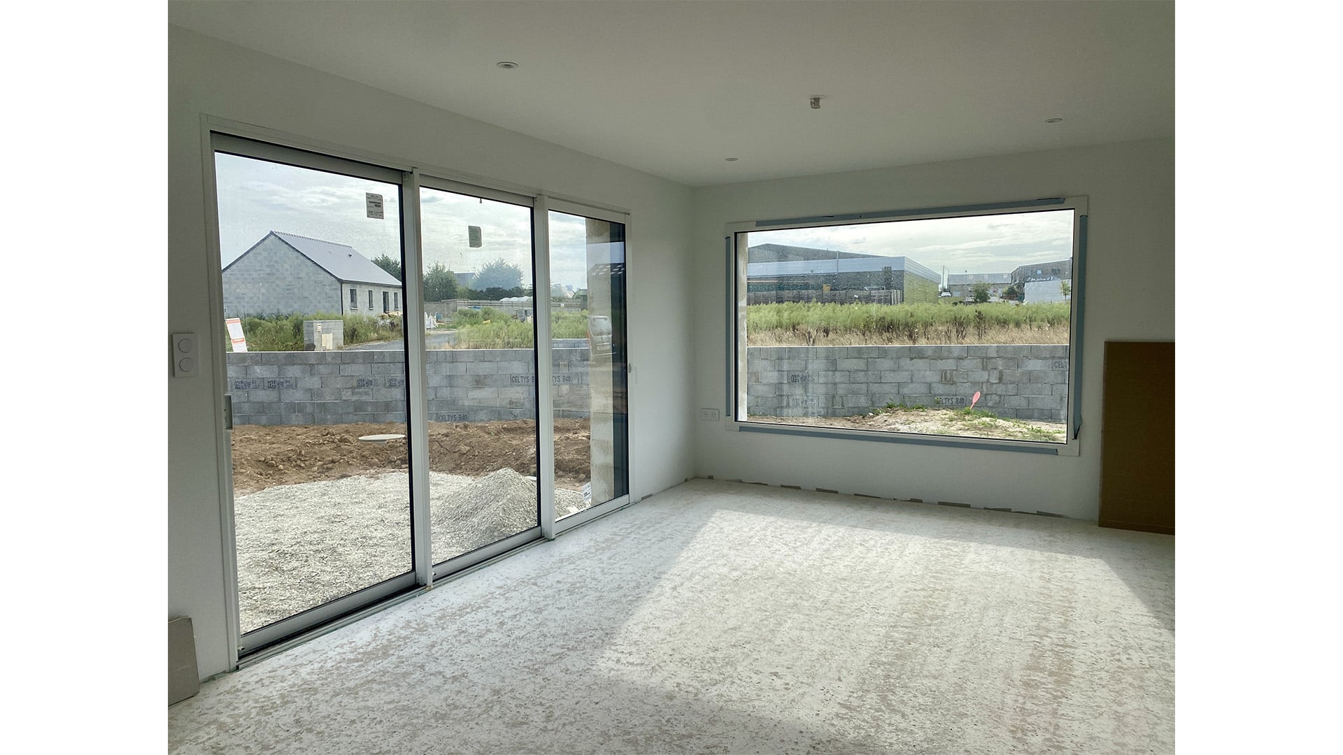 Séjour lumineux avec grande baie fixe, maison d'architecte à Plouvorn