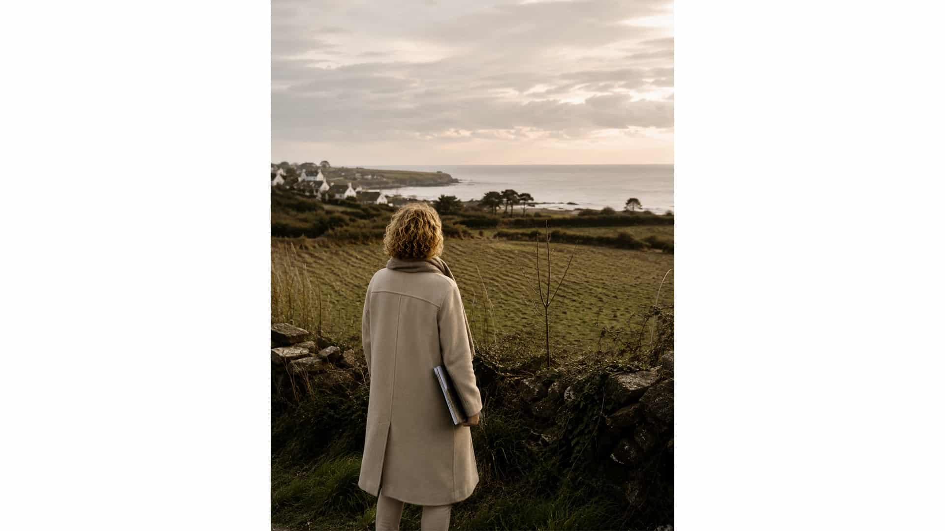 Mélanie Le Gall, architecte, observant un site en bord de mer dans le Finistère