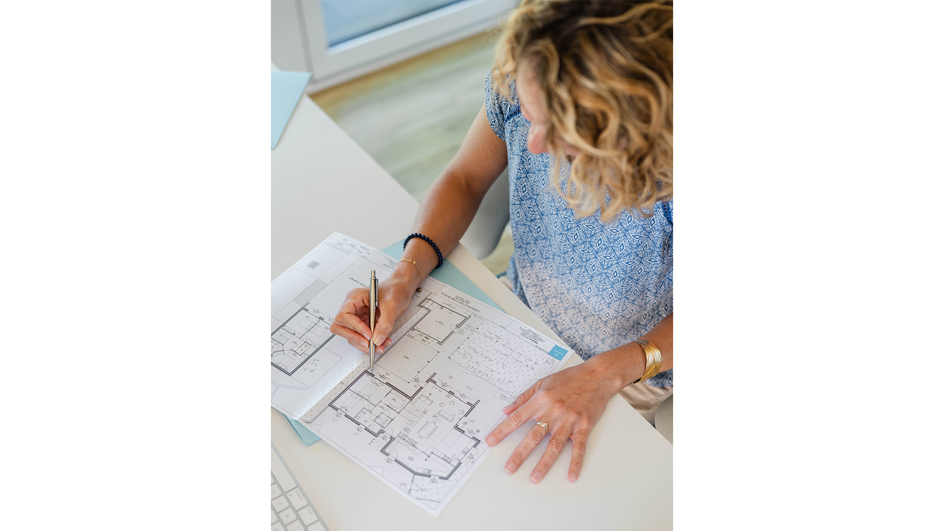 Mélanie Le Gall annotant les plans d'une maison à son bureau de Roscoff